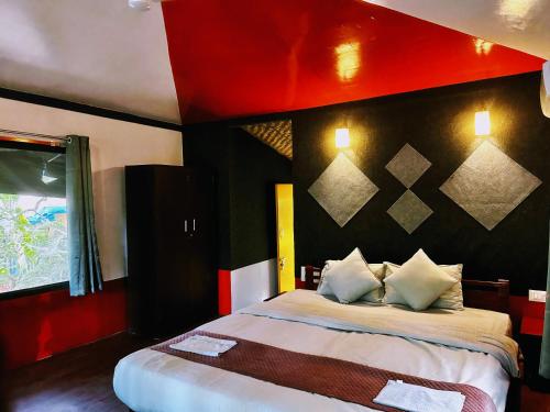 a bedroom with a large bed with a red wall at Samyama Retreat in Cola