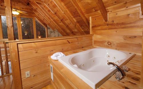 a bathroom with a tub in a log cabin at Highland Hideaway in Gatlinburg