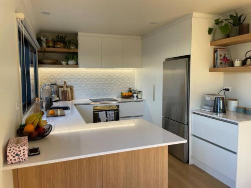 a kitchen with a white counter top and a refrigerator at Cosy on Campbell in Mount Maunganui