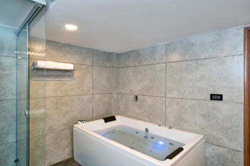 a bathroom with a bath tub and a shower at Serene Horizon in Thekkady