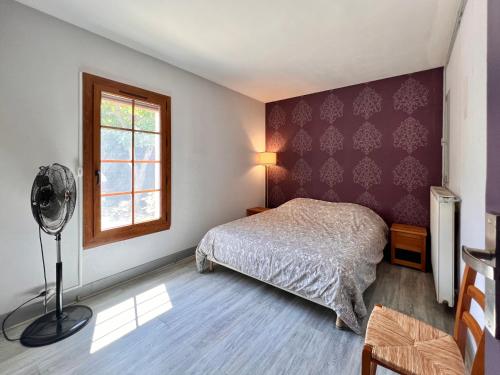 Maison 12 personnes max proche Mer et parkings gratuits في لو غراو دو روا: غرفة نوم بسرير ونافذة ومروحة