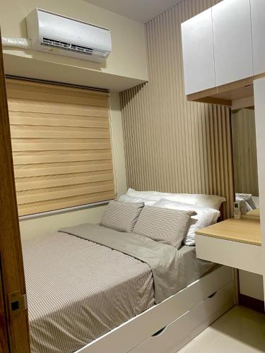 a small bedroom with a bed in a room at Coast Residences condo near MOA, StarCity and PICC in Manila