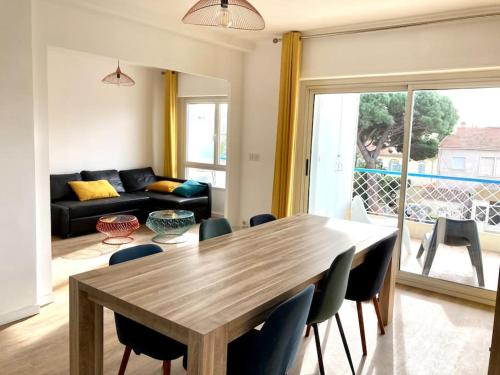 un salon avec une table et des chaises en bois dans l'établissement T3 lumineux et climatisé à 300m des plages, à La Seyne-sur-Mer