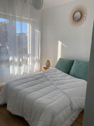 une chambre avec un grand lit et une fenêtre dans l'établissement T3 lumineux et climatisé à 300m des plages, à La Seyne-sur-Mer