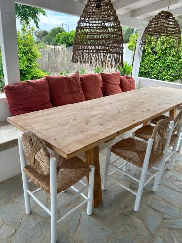 a wooden table with two chairs and a couch at Maison Filo&Sofia in Porto Heli