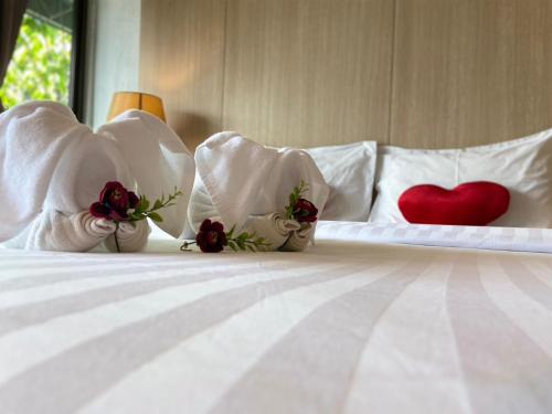 a bed with white pillows with a red heart on it at A Plus Deluxe Hotel in Ko Lipe