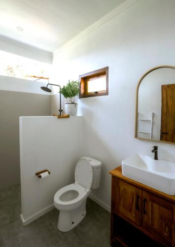 a bathroom with a toilet and a sink at Rumah Markisa Batukaras in Batukaras
