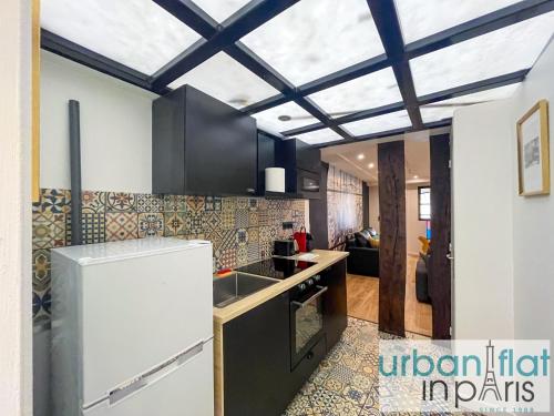 une cuisine avec un évier et une cuisinière four supérieur dans l'établissement Urban Flat 120 - Charming 3 bedroom Flat in Le Marais, à Paris