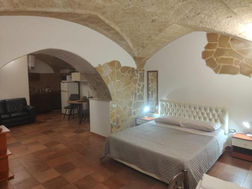 a bedroom with a bed and a stone wall at Casa Vacanza De Flagilla in Brindisi