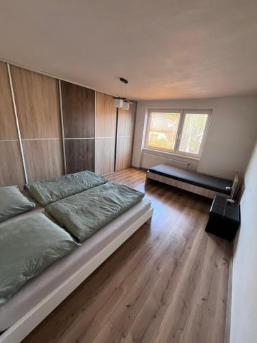 a bedroom with a large bed and wooden floors at Dom Udavské in Udavské