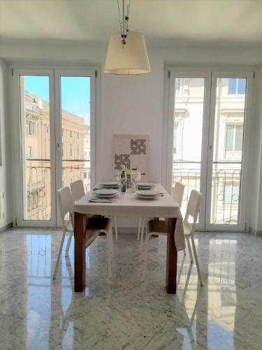 a white dining room with a white table and chairs at Ducale interno 5 in Genova