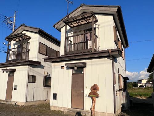 a building with a woman painted on the side of it at Minpaku Hasegawa A in Numata