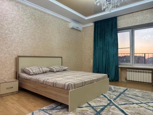 a bedroom with a bed and a chandelier at 3 комнатная ЖК Альтаир in Aktobe