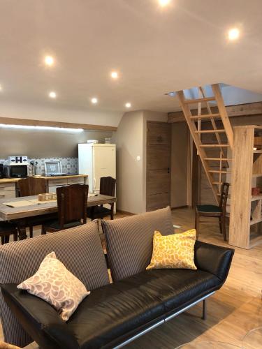 un salon avec un canapé et un escalier dans l'établissement Le duplex de l ancienne forge, à Muhlbach-sur-Munster