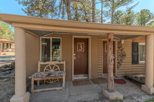 a small house with a bench in front of it at Enchanted Hideaway Cabins and Cottages in Ruidoso