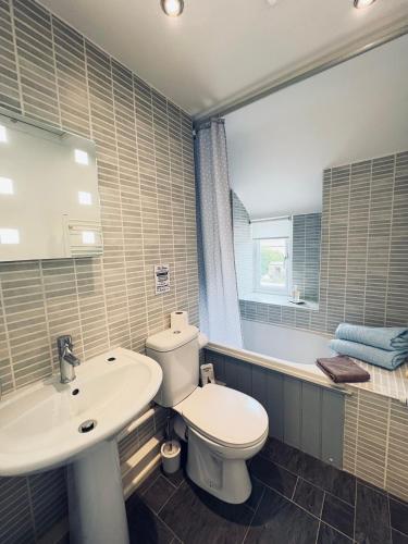 a bathroom with a toilet and a sink and a tub at Silhouette Cottage in Coleford