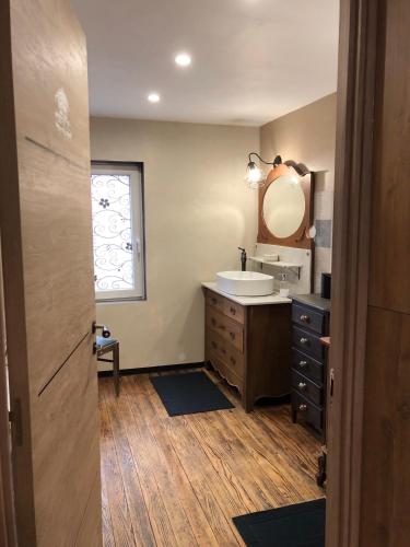 une salle de bain avec un lavabo et un miroir dans l'établissement Le duplex de l ancienne forge, à Muhlbach-sur-Munster
