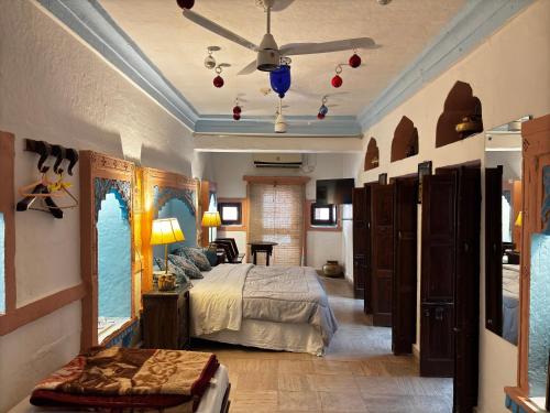 a bedroom with a bed and a ceiling fan at Shahi Guest House in Jodhpur