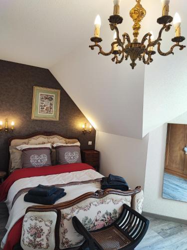 une chambre avec un lit et un lustre dans l'établissement Chez 