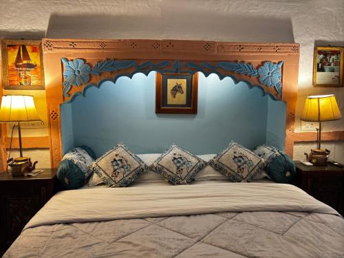 a bedroom with a large bed with a blue headboard at Shahi Guest House in Jodhpur