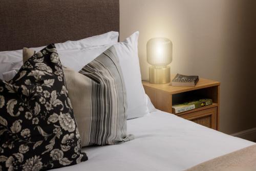 a bed with a pillow and a nightstand with a lamp at The Turf in Exminster