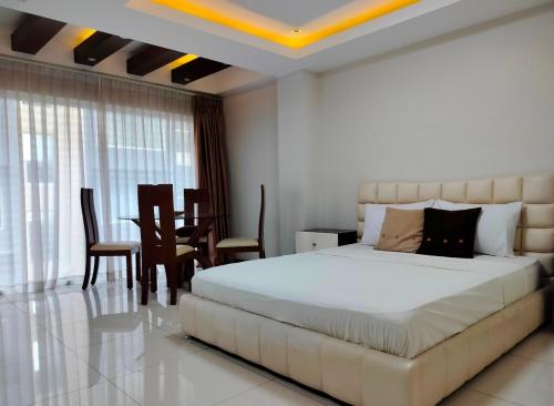 a bedroom with a large bed and a dining room at La grande Hotel & Residence in Angeles