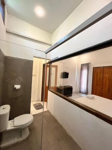 un baño con inodoro y bañera en Bale sunrise, en Gili Trawangan