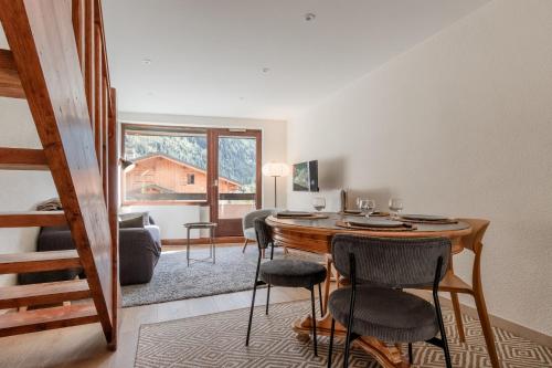 une chambre avec une table et des chaises ainsi qu'un salon dans l'établissement Les Chamois - Duplex - Vue magnifique, à Chamonix-Mont-Blanc