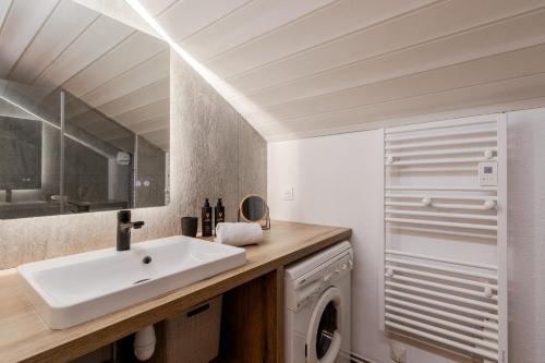 une salle de bain avec un lavabo et une machine à laver dans l'établissement Les Chamois - Duplex - Vue magnifique, à Chamonix-Mont-Blanc