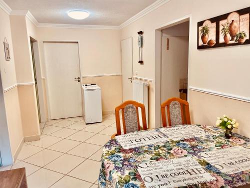 a dining room with a table and chairs and a refrigerator at Villa Lux in Hévíz