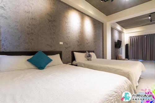 a hotel room with two beds and a television at 宜蘭包棟民宿 蘭田會館 電動麻將 KTV Switch 德州撲克 燒烤 廚房 充電樁 寵物友善 in Yuanshan