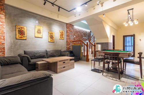 a living room with a couch and a pool table at 宜蘭包棟民宿 蘭田會館 電動麻將 KTV Switch 德州撲克 燒烤 廚房 充電樁 寵物友善 in Yuanshan