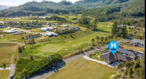 an aerial view of the golf course at a resort at Golf at the beach in Pauanui
