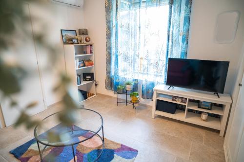 a living room with a flat screen tv and a table at Casa Mura in Bracciano