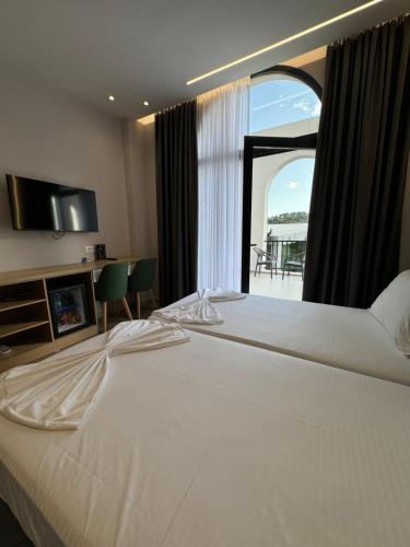 a large white bed in a room with a window at Hotel Panorama & Spa Elbasan in Elbasan
