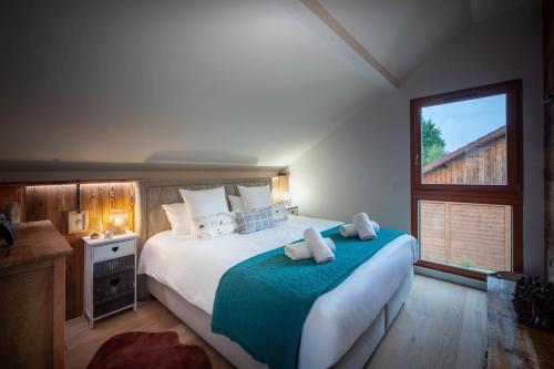 une chambre avec un grand lit et une fenêtre dans l'établissement Chalet Mökki, bain nordique, balnéo et sauna, à Xonrupt-Longemer