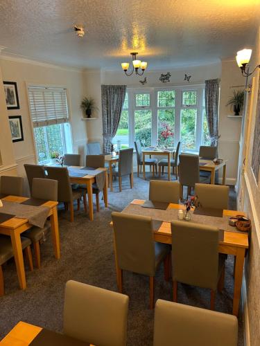 a dining room with tables and chairs and windows at The Russell in Scarborough