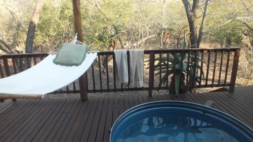 a hammock on a deck next to a pool at Pheasant's Crest in Marloth Park