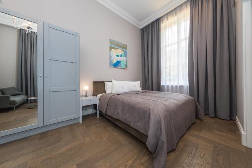 a bedroom with a bed and a large window at Vila Komoda in Palanga