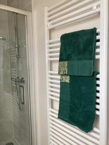 a green towel hanging on a towel rack in a bathroom at House-Sleeps 8-Parking-Garden in Weekley