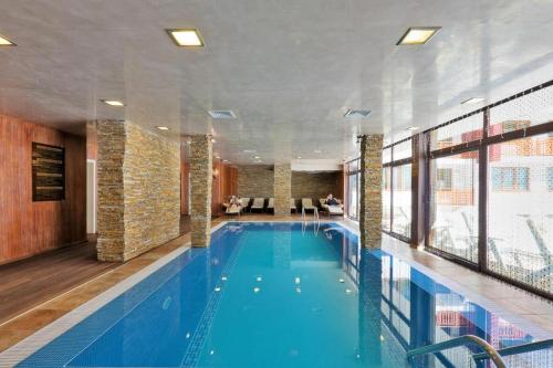 ein großer Swimmingpool in einem Hotelzimmer in der Unterkunft Апартамент в Лъки Пампорово комплекс in Pamporowo