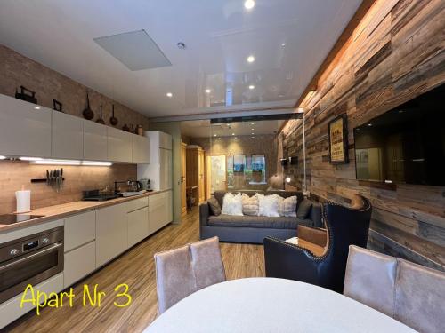 a kitchen and a living room with a couch at Alpenburg Bergparadies Apartments in Wald am Arlberg