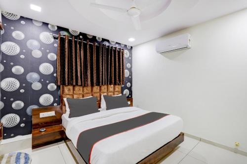 a bedroom with a bed and a wall with dots at Collection O Lotus Gold in Vadodara