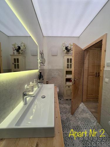 a bathroom with a large white sink and a mirror at Alpenburg Bergparadies Apartments in Wald am Arlberg