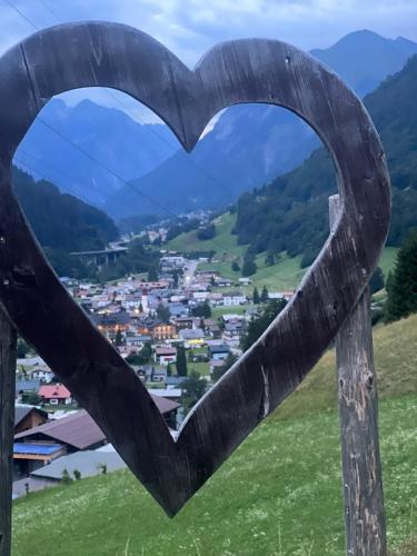 a heart carved out of a wooden post with a view at Alpenburg Bergparadies Apartments in Wald am Arlberg
