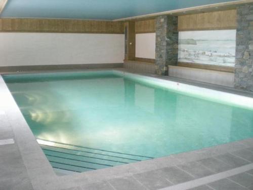une grande piscine dans un immeuble dans l'établissement Au pied des pistes, dans une résidence de standing, à Cohennoz