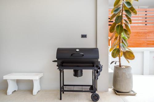 a grill on a cart in a room with a plant at come home pool villa cha-am in Phetchaburi