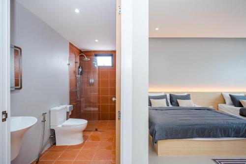 a bedroom with a bed and a bathroom at come home pool villa cha-am in Phetchaburi
