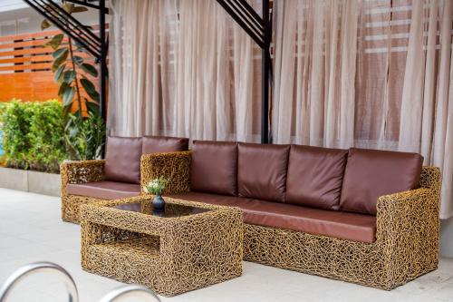 a brown couch and a table in a room at come home pool villa cha-am in Phetchaburi