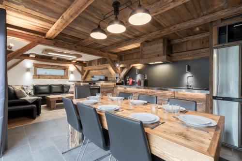 une cuisine et une salle à manger avec une table et des chaises en bois dans l'établissement Le Covagnet, à Saint-Gervais-les-Bains